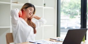 Woman stretching while sitting at a desk